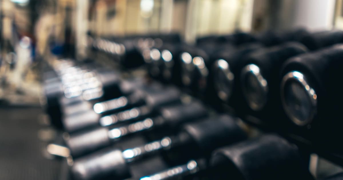 Athlete training with dumbbells in a modern gym